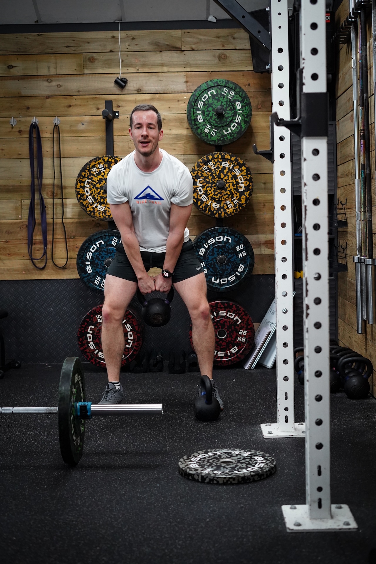Weight room with barbells and plates at The Zone Neston